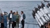 In this June 23, 2016 file photo released by the Indonesian Presidential Office, Indonesian President Joko Widodo, third right, accompanied by Indonesian officials on navy warship KRI Imam Bonjol, at the Natuna Islands, Indonesia.