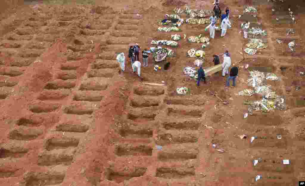 Cemetery workers in protective clothing bury three victims of the new coronavirus at the Vila Formosa cemetery in Sao Paulo, Brazil. Brazil is nearing two million cases of COVID-19 and 75,000 deaths. 