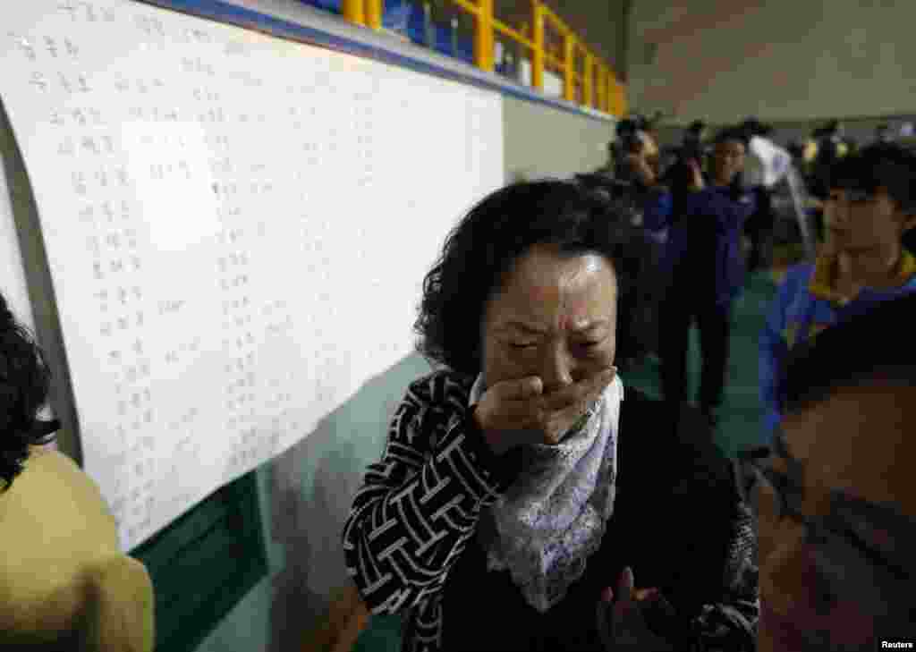 16일 한국 진도 해상에서 침몰한 여객선 세월호에 탑승했던 학생의 어머니가 생존자 명단을 확인한 후 울음을 터트리고 있다.