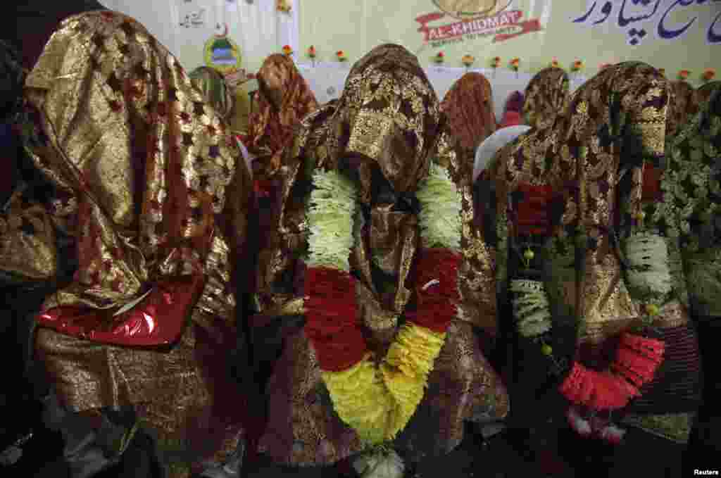 Para pengantin perempuan duduk bersama dalam sebuah upacara pernikahan massal di Peshawar. Total 25 pasangan dari provinsi Khyber Pakhtunkhwa di Pakistan barat laut berpartisipasi dalam acara tersebut, yang diselenggarakan oleh Yayasan Al-Khidmat. 