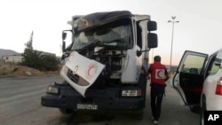 This image provided by the Syrian Arab Red Crescent shows the aftermath of an attack on a humanitarian aid convoy that came under fire shortly before dark Saturday, June 17, 2017, outside Damascus, Syria.