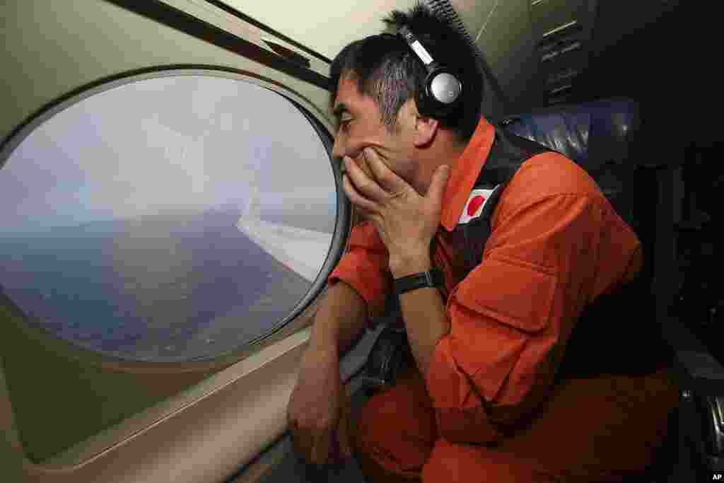 Koji Kubota, anggota Penjaga Pantai Jepang melakukan pencarian selagi terbang di wilayah pencarian sisa-sisa MH370, 1 April 2014.