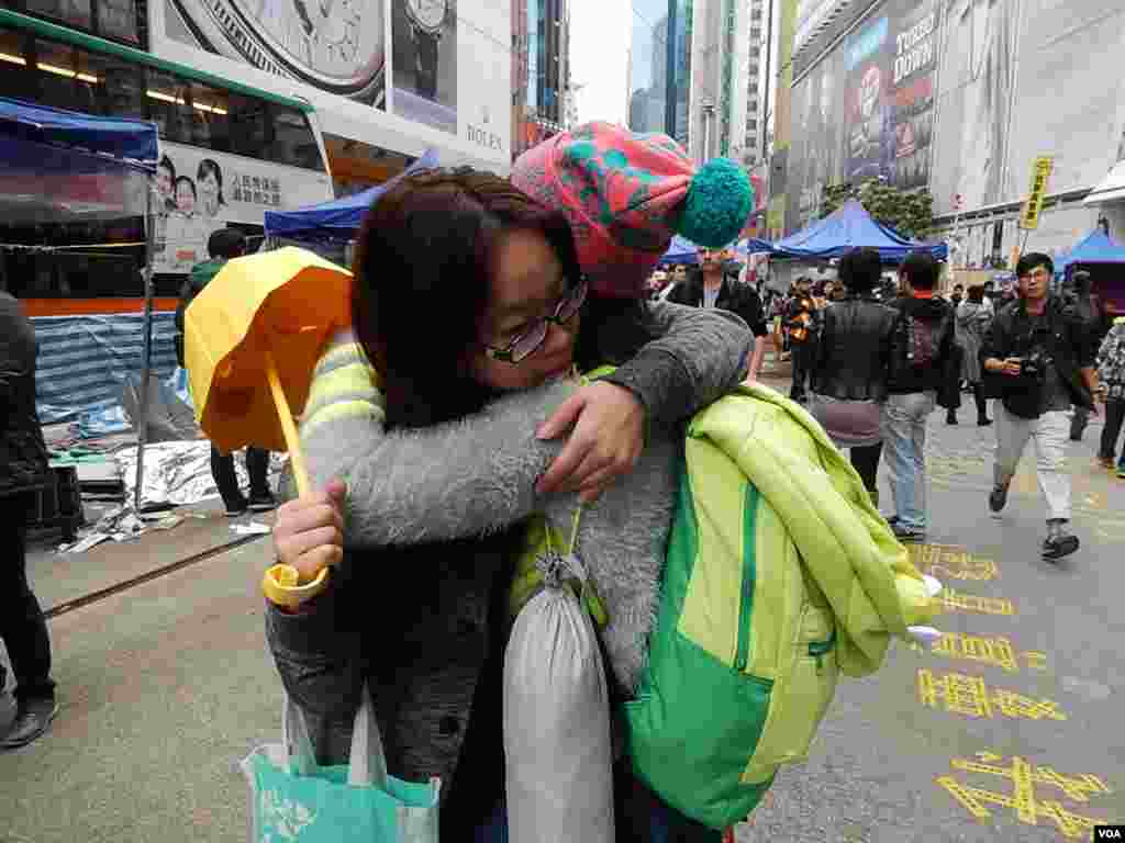 銅鑼灣佔領區留守者徐小姐(戴眼鏡者)在清場前與其他留守者擁抱道別