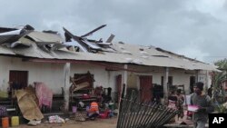 Mwanamume akitembea karibu na jengo lililoharibiwa na kimbunga Freddy tarehe 22, Februari 2023, baada ya kimbunga hicho kutua Madagaska. Picha na AP/Solofo Rasolofomanana.