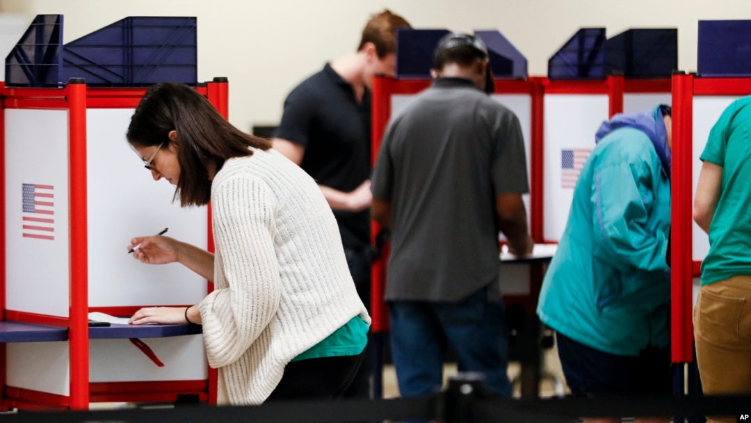 Voters fill out their ballots on the first day of early voting at the Hamilton County Board of Elections, Wednesday, Oct. 10, 2018, in Cincinnati. In-person voting has begun in swing-state Ohio for the Nov. 6 elections for governor, U.S. Senate, House seats and a host of other state and local offices and issues. (AP Photo/John Minchillo)