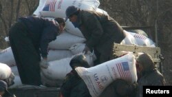 지난 2008년 12월 북한 신의주 주민들이 미국에서 지원한 식량을 트럭에서 내리고 있다. 식량 자루에 'USAID(미국제개발처)' '미국에서 보내온 선물' 이란 문구가 씌여있다. (자료사진)
