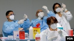 Trabajadores de la salud italianos preparan dosis de vacunas contra el coronavirus en un centro de inmunización en Nápoles, Italia, en enero pasado.