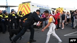 Arhiv -Policajac zaustavlja demonstranta tokom demonstracija koje su sazvali ekstremno desničarski aktivisti u Weymouthu, na jugozapadnoj obali Engleske, gdje je privezana barža za smještaj migranata Bibby Stockholm, 4. augusta 2024.