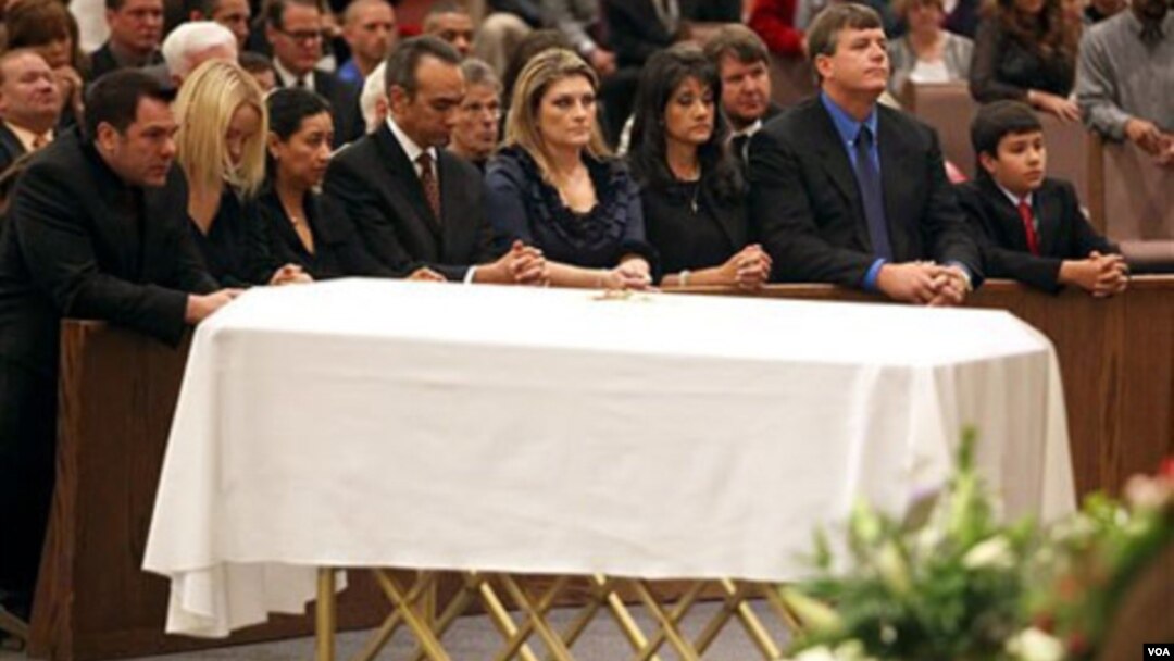 La familia junto al ataúd de Christina Green, su madre Roxanna, la tercera de la derecha, el padre John, segundo de la derecha y el hermano Dallas durante el funeral.