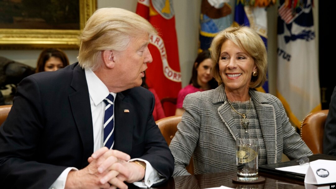 FILE - In this Feb. 14, 2017 file photo, President Donald Trump talks to Education Secretary Betsy DeVos in the Roosevelt Room of the White House in Washington. A new study published Tuesday has found increased support for charter schools and private school voucher programs. The study suggests that Republican Party support for these programs had a strong influence on the increase. (AP Photo/Evan Vucci, File)