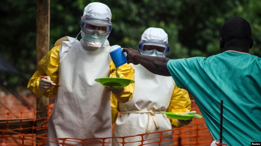 FILE - Medical staff working with Doctors Without Borders prepare to take food to patients in the isolation area of an Ebola treatment center in Sierra Leone's Kailahun district.