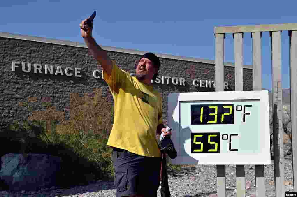 Greg Berndt takes a selfie with the thermometer reading 132° F (55.5° C) at the Furnace Creek Visitors Center in Death Valley, California, Aug. 17, 2020.
