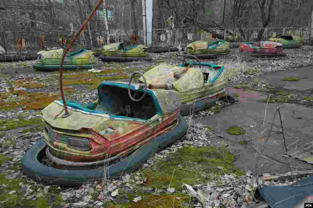 Wahana permainan anak yang rusak di taman bermain dengan kadar radioaktif tinggi di Pripyat, dekat Chernobyl (19/3). (VOA/Steve Herman)