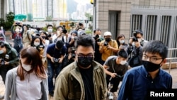 （自右至左）前香港眾志秘書長黃之鋒、主席林朗彥及成員周庭2020年11月23日到達西九龍裁判法院出庭受審（路透社）
