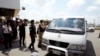 A van drives four refugees from Australia out of Phnom Penh International Airport, in Phnom Penh, Cambodia, Thursday, June 4, 2015.