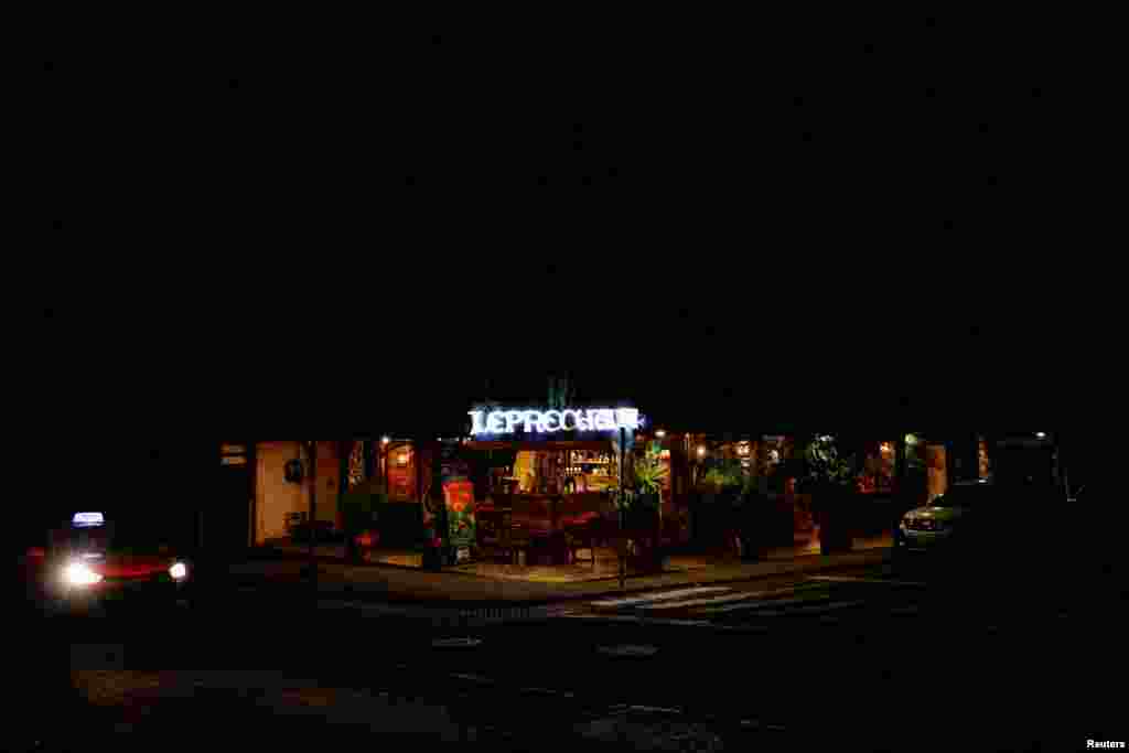 Un bar iluminado por un generador portátil parece vacío durante un apagón nacional por mantenimiento en el sistema eléctrico del país durante la noche del miércoles, en Puyo, Ecuador, el 18 de septiembre de 2024. REUTERS/Karen Toro 
