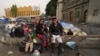 La familia Aguilar Bastida, procedente de Venezuela, fuera de la iglesia de la Santa Cruz y La Soledad, en donde algunos migrantes acampan, el martes 26 de diciembre de 2023, en Ciudad de México.