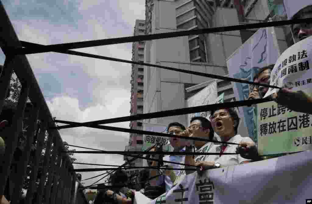 Para demonstran pro-demokrasi memajang pita hitam di depan kantor pemerintah China di Hong Kong, sebagai protes atas penangkapan aktivis. 