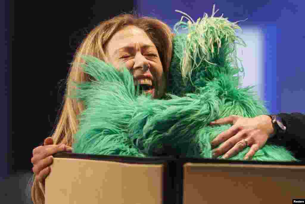 Chelsea Clinton, daughter of former U.S. President Bill Clinton, hugs "Rosita the Muppet" on stage during the Clinton Global Initiative 2013 (CGI) in New York, Sept. 24, 2013.