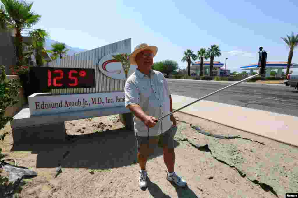 Benito Almojuela mengambil selfie dekat termomoter yang menunjukkan suhu 125 derajat Fahrenheit, di Palm Springs, California, 20 Juni 2016.