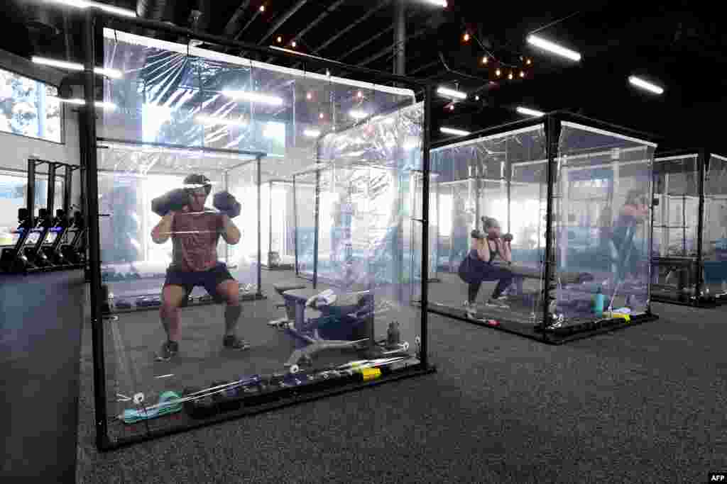 People exercisein their workout pods while observing social distancing at Inspire South Bay Fitness, June 15, 2020, in Redondo Beach, as the gym reopens under California's coronavirus Phase 3 reopening guidelines.